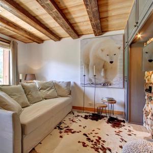 Le BiotL'Ours Blanc Lodge的客厅配有沙发和北极熊的照片