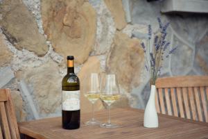 多尔切阿夸Terre Bianche Appartamenti的桌子上放有一瓶葡萄酒和两杯酒