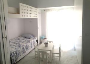 圣玛丽亚港Apartamento Playa Muralla的一间卧室配有一张床和一张桌子及椅子