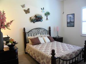 珊瑚角Villa Cape Florida的一间卧室配有一张黑色床架和墙上的蝴蝶床。
