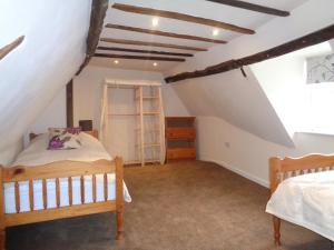 YoxfordMinsmere Cottage的阁楼上的卧室配有两张床