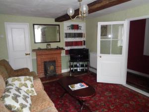 YoxfordMinsmere Cottage的带沙发和壁炉的客厅