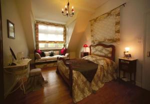Courcelles-Chaussy兰顿维尔斯磨坊酒店的一间卧室配有一张床、一张沙发和一个窗口