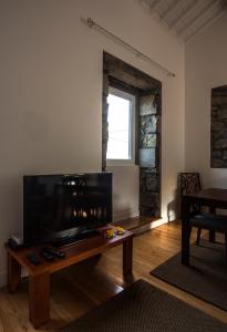 诺德什蒂Casa do Simão的客厅配有桌子和大屏幕电视