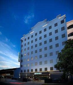新加坡Hotel 81 Premier Hollywood的一座白色的大酒店建筑,拥有蓝色的天空