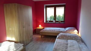 布兰斯科Apartment Těchov的红色的客房设有两张床和窗户。