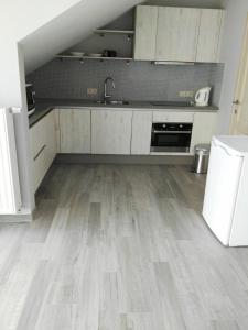 弗尔内Guesthouse SiSa的厨房铺有木地板,配有白色橱柜。