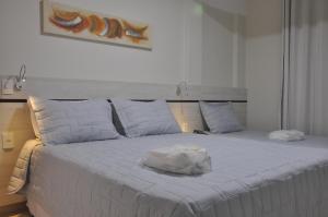 瓜拉派瑞Hotel Raio de Sol的一张白色的床,上面有一条毛巾