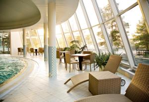 波里艺特瑞Spa酒店的大型客房设有游泳池、桌子和椅子。