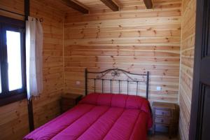 Navas de Estena林斯特加贝内罗斯乡村民宿 - 乡村旅游中心的小木屋内一间卧室,配有一张床
