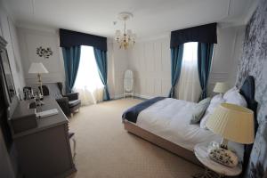 克拉约瓦Hotel Splendid 1900的一间卧室配有一张带蓝色窗帘的大床