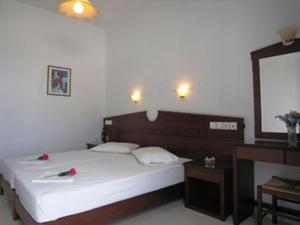 迈洛波塔斯伊尔皮斯酒店的一间卧室配有一张带镜子和桌子的大床