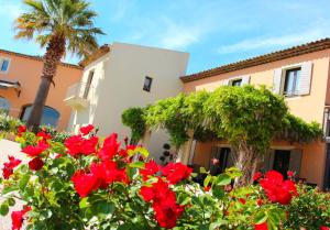 罗克布伦河畔阿尔让勒达亚Spa酒店的一座满是红花和棕榈树的房子