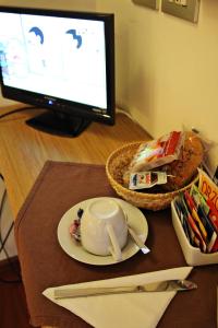 佩鲁贾普瑞玛维拉迷你酒店的一张桌子,上面有电脑显示器,碗和盘子