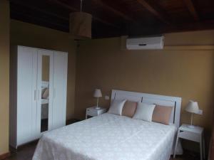 亚伊萨Finca Esperanza的卧室配有白色的床、两张桌子和风扇