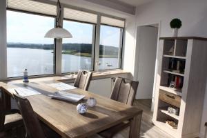 石勒苏益格Ostseefjord-Schlei-Blick im Wikingturm的餐桌、椅子和大窗户