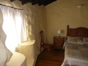 格拉纳迪利亚德亚沃纳佩帕乡村民宿的卧室配有床、椅子和窗户。