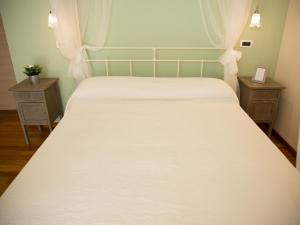 Controguerra威尔第柯林尼乡村民宿的一间卧室配有白色床和2个床头柜