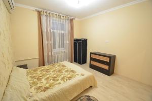 尼古拉耶夫Lux Apartment Sobornaya的一间卧室配有一张床、一个梳妆台和一扇窗户。