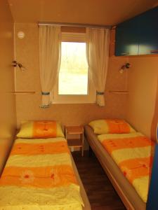 ŠempasMobilehouse & Camping Lijak的小型客房 - 带2张床和窗户