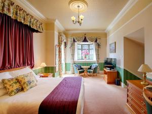 因弗戈登金格莱格城堡酒店的一间卧室配有一张床、一张书桌和一个窗户。