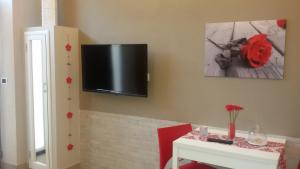 锡拉库扎Mishalay Apartment的一间设有桌子和墙上电视的房间