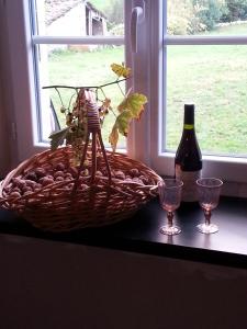 Saint-BasileLa Maison Des Badons的一篮葡萄和一瓶葡萄酒及眼镜