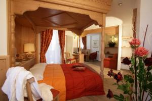 安达洛罗察加尼酒店的一间卧室配有一张带红色毯子的天蓬床
