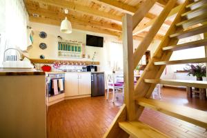 奥尔什丁Siedlisko Grabinowo k/Olsztyna的铺有木地板的厨房和木制楼梯