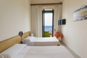 圣凯撒利亚温泉普拉兹酒店的酒店客房设有两张床和窗户。
