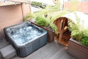 马尔梅迪Suite 40 Jacuzzi & Sauna by Malmedreams的植物甲板上的热水浴池