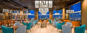 东京王子画廊东京纪尾井町豪华精选酒店的餐厅设有蓝色的椅子和桌子以及窗户。
