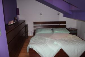 布拉格Sunny Two-story Apartment Kyje的一间卧室设有一张大床,拥有紫色的天花板