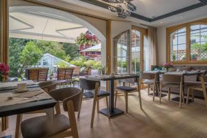 采尔马特伊甸园酒店的餐厅设有桌椅和窗户。