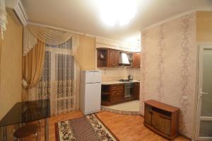 尼古拉耶夫安德瑞斯卡亚VIP公寓的厨房配有白色冰箱和木制橱柜。