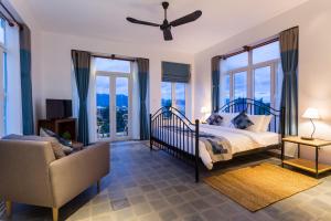 贡布贡布精品酒店的一间卧室配有一张床、一把椅子和窗户。