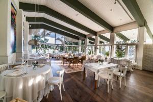 VilloldoH＆R艾斯特莱拉卡里翁旅馆的餐厅设有白色的桌椅和窗户。