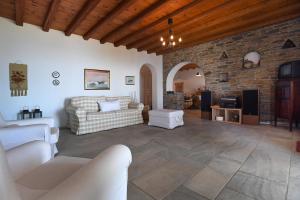 ArnadosTinos Sky View Villa的带沙发和石墙的客厅