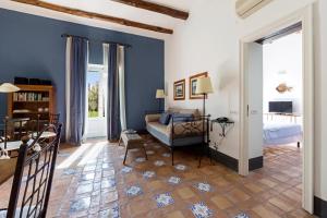 索伦托乔凡娜瑞加纳酒店的一间拥有蓝色墙壁的卧室,配有一张床和一张桌子