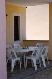 巴德希La dimora del Murales - Holiday home的周围设有白色的桌子和白色的椅子