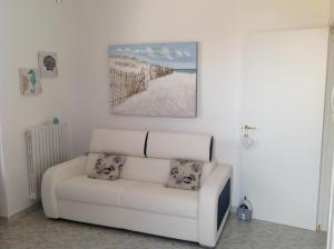 萨维勒特里Maricasa Savelletri的客厅的白色沙发,墙上有绘画作品