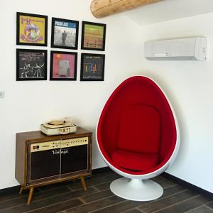 TuletteLa Datcha Delicatessen的红色椅子和客房内的电视