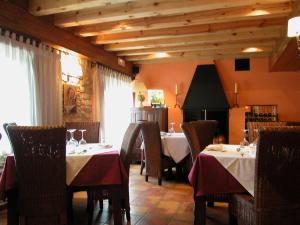 Cabrejas del Pinar斯提阿卡米诺德拉福恩特纳酒店的一间用餐室,配有两张桌子和椅子,配有红色桌布