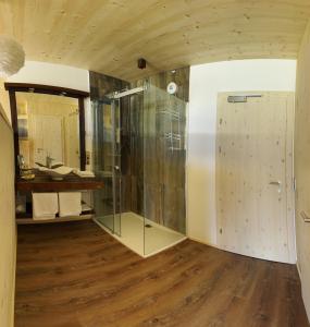 利恩茨Wildauers Haidenhof STAY & SLEEP的一间带玻璃淋浴间的浴室,铺有木地板