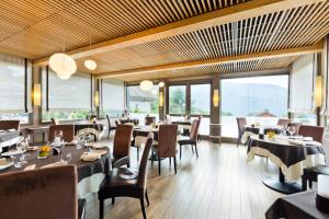 雷加霍斯达哈施萨沃伊拉克罗伊克斯&Spa酒店的餐厅设有桌椅和大窗户。