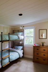 黑荒地拉兰吉精品度假屋的一间卧室设有两张双层床和一扇窗户。
