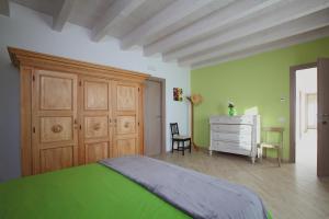 Invorio InferioreCascinetta32的一间绿色卧室,配有床和梳妆台