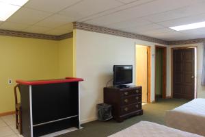 Canaan伯克希尔旅行旅馆的一间设有床铺的房间和一个带电视的梳妆台