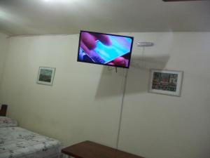 伊利亚贝拉Chalés Xibayka Ilhabela的卧室墙上的平面电视