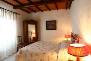 福利亚Casa Terra Rossa的一间卧室配有一张带两盏灯和镜子的床